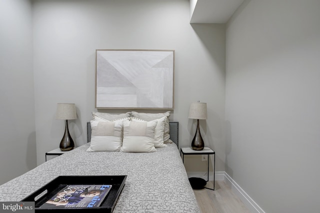 bedroom featuring baseboards and wood finished floors