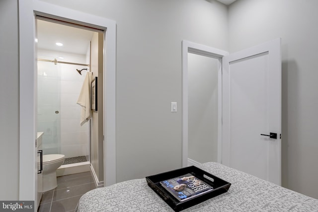 bathroom featuring tile patterned flooring, a shower stall, and toilet