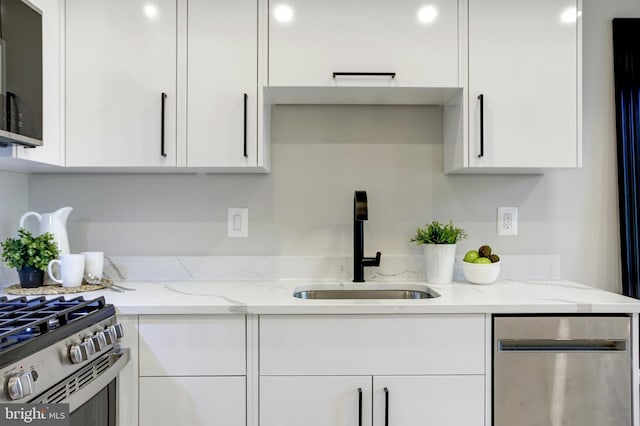 kitchen featuring stainless steel appliances, white cabinets, and a sink