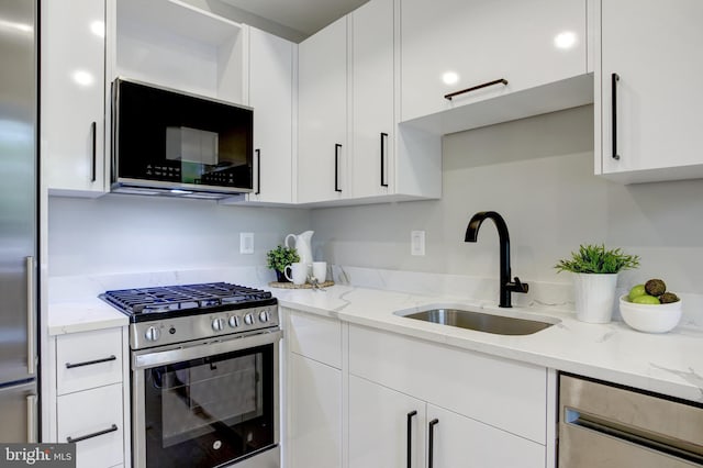 kitchen featuring stainless steel appliances, white cabinetry, and a sink