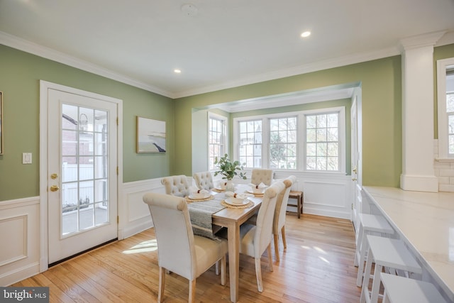 dining room with recessed lighting, wainscoting, crown molding, and light wood-style floors