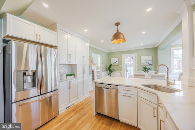 kitchen featuring a sink, plenty of natural light, appliances with stainless steel finishes, and white cabinetry