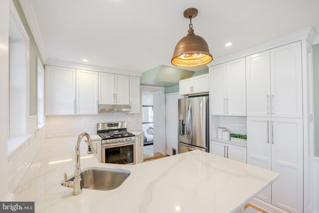 kitchen with a sink, decorative backsplash, under cabinet range hood, appliances with stainless steel finishes, and white cabinetry