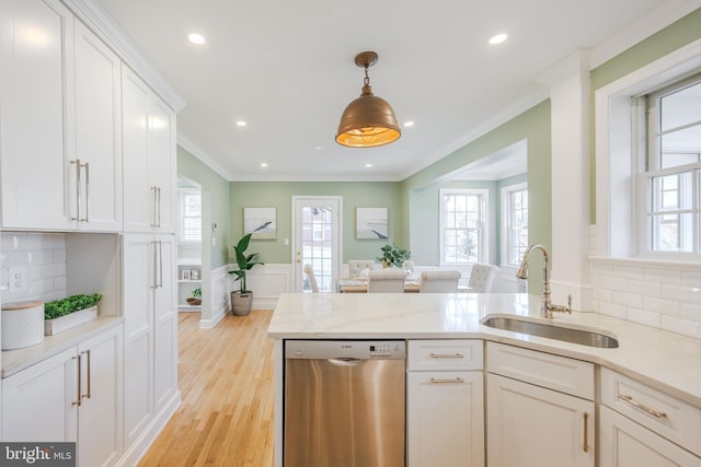 kitchen featuring ornamental molding, a sink, stainless steel dishwasher, white cabinets, and light wood finished floors