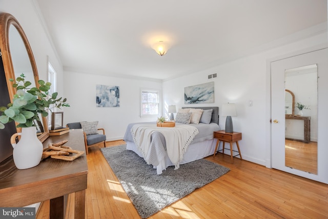 bedroom with light wood-style flooring, baseboards, and visible vents