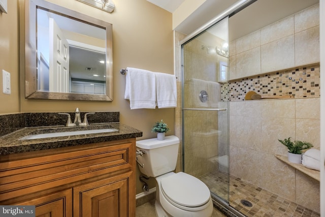 full bathroom with toilet, a stall shower, and vanity