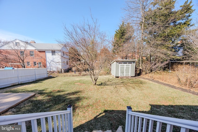 view of yard with a storage shed, an outdoor structure, and fence