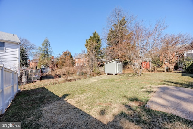 view of yard featuring a storage unit, an outbuilding, and fence