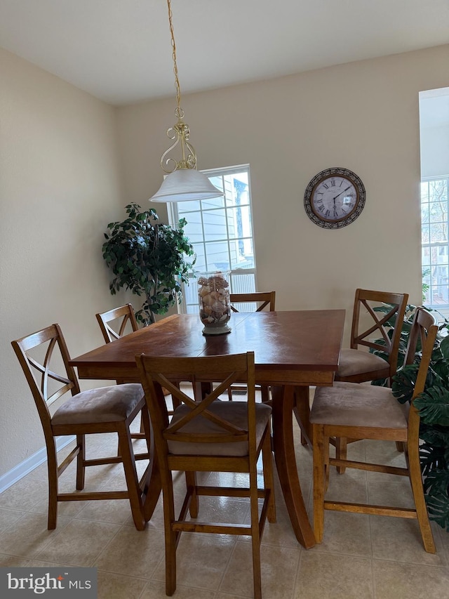 dining area featuring light tile patterned floors and baseboards