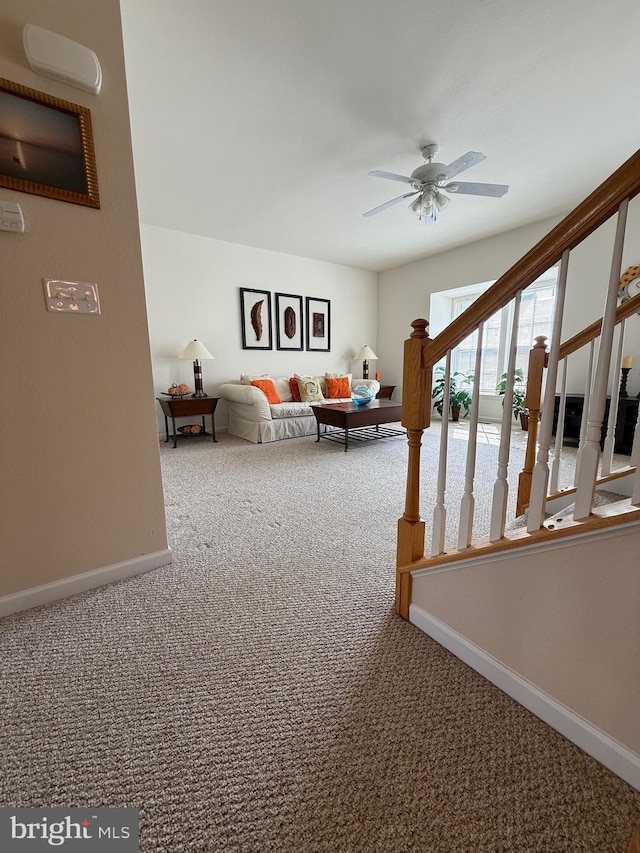 unfurnished living room with carpet, stairs, baseboards, and ceiling fan