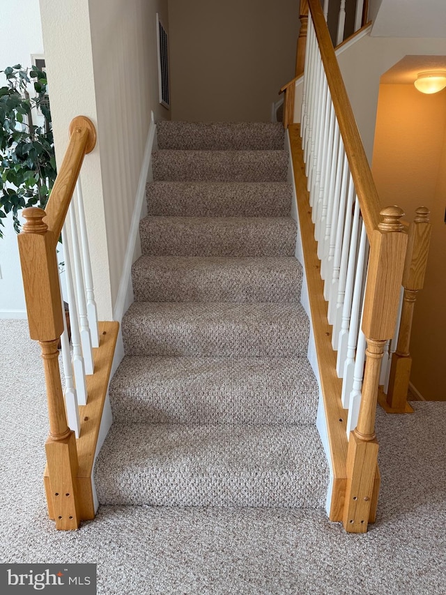 stairway featuring visible vents and baseboards