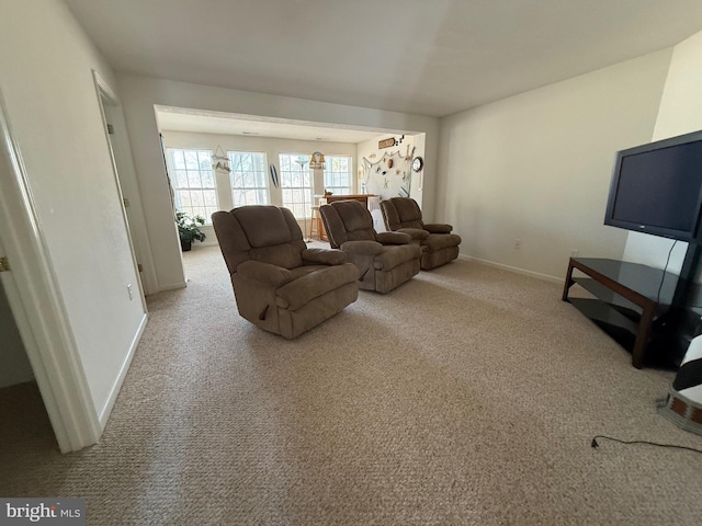 carpeted living room featuring baseboards