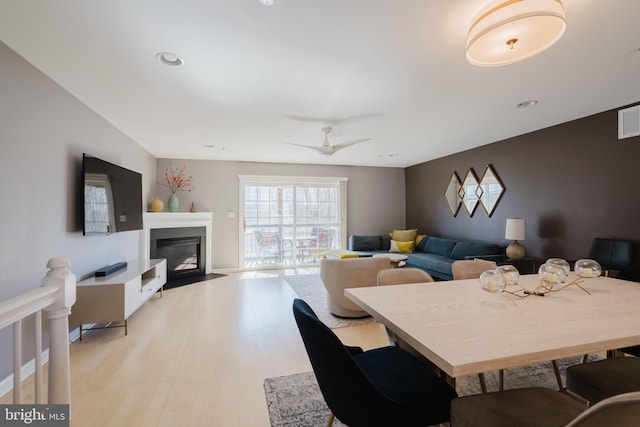 dining area with visible vents, a fireplace with flush hearth, a ceiling fan, recessed lighting, and light wood-style floors