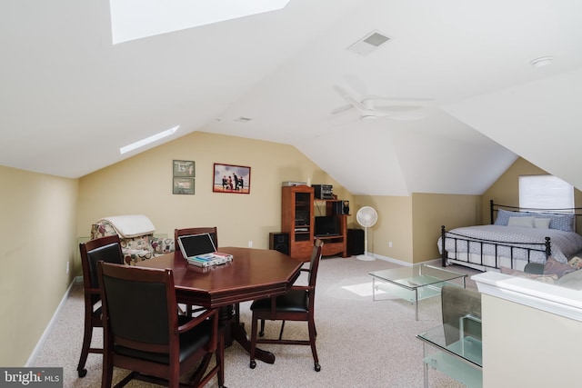 dining room with visible vents, baseboards, light colored carpet, vaulted ceiling, and a ceiling fan