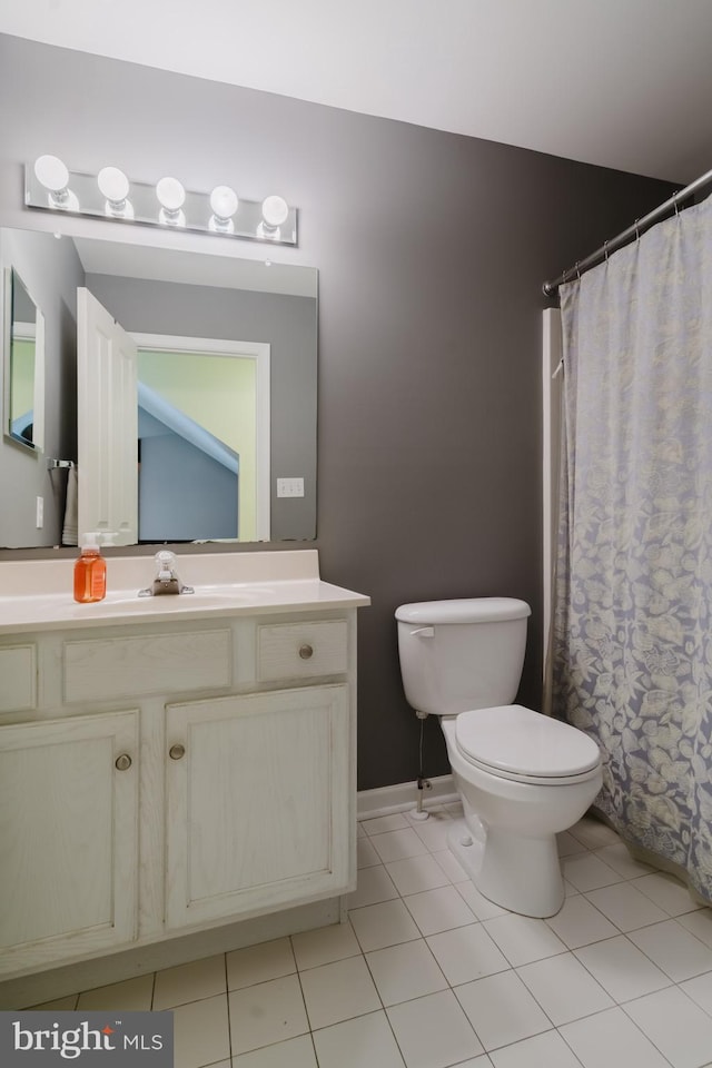 bathroom featuring tile patterned flooring, toilet, vanity, and baseboards