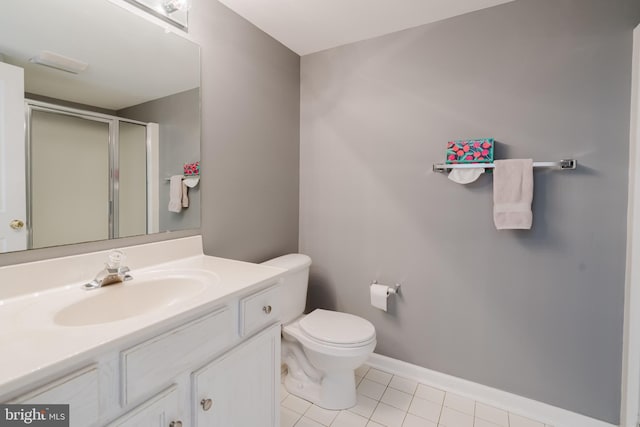 bathroom featuring vanity, baseboards, tile patterned flooring, a shower stall, and toilet