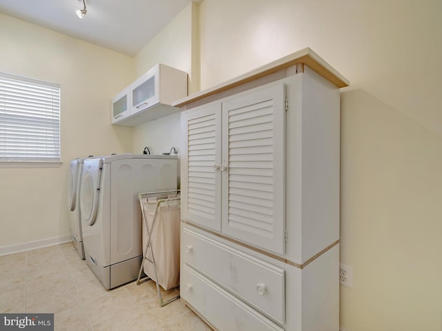 laundry area with laundry area, light tile patterned flooring, baseboards, and washing machine and clothes dryer