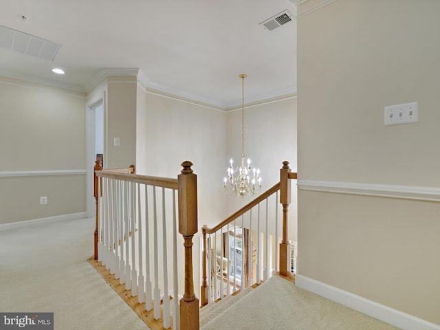 hall with visible vents, carpet flooring, and an upstairs landing