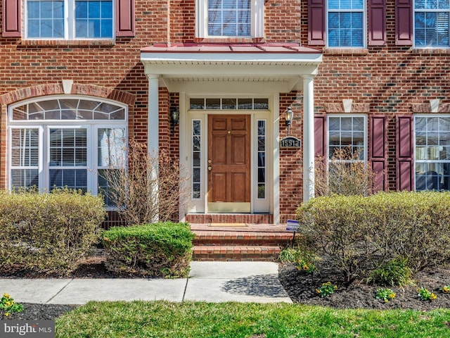 doorway to property featuring brick siding