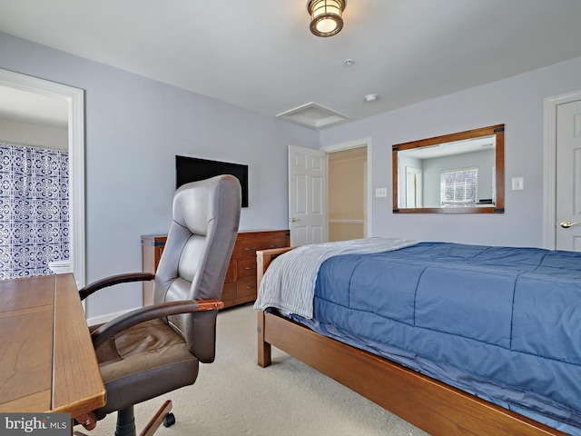 bedroom featuring attic access and carpet flooring