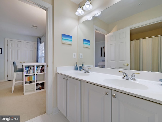 bathroom with double vanity, visible vents, and a sink