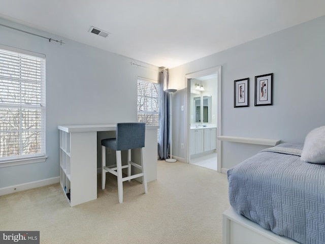 bedroom featuring light carpet, visible vents, baseboards, and ensuite bathroom