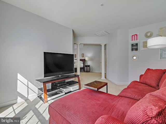 living area with baseboards, light carpet, visible vents, and ornate columns