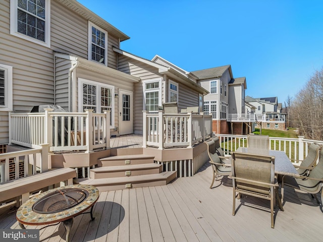 deck with a fire pit and outdoor dining space