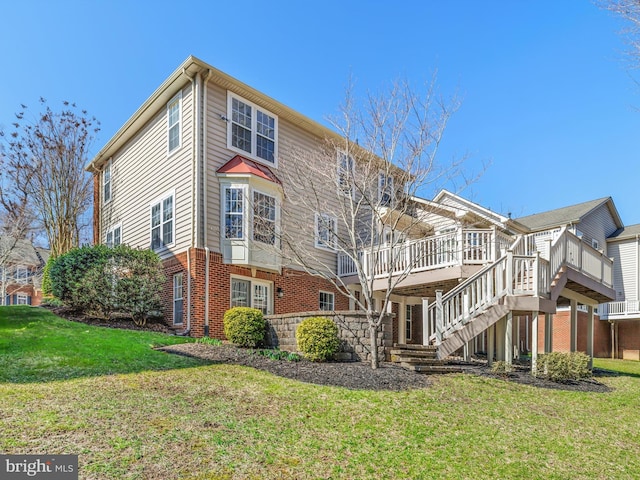 view of side of property with brick siding, a lawn, a wooden deck, and stairs