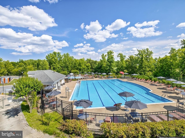 community pool with fence and a patio