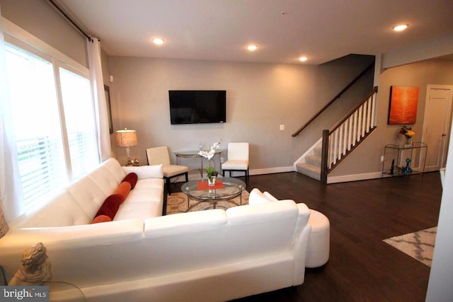 living room featuring stairs, baseboards, wood finished floors, and recessed lighting