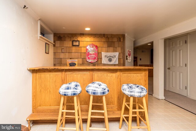 bar with recessed lighting, baseboards, a bar, and crown molding