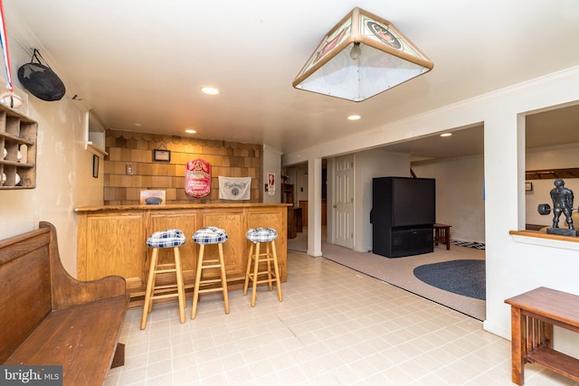 interior space featuring recessed lighting, a dry bar, and ornamental molding