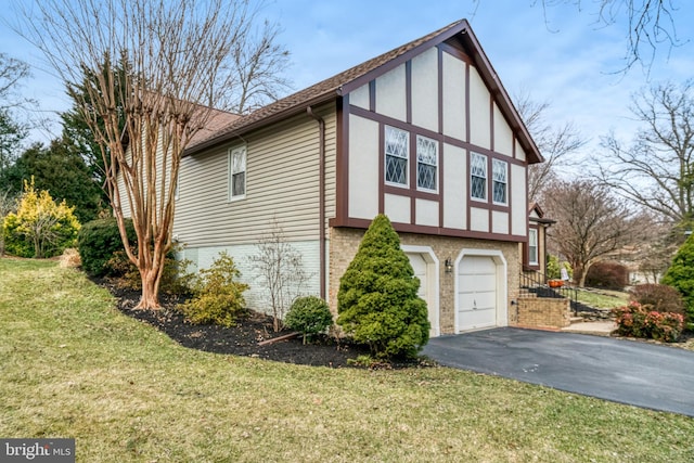 view of side of property featuring driveway, brick siding, a lawn, an attached garage, and stucco siding