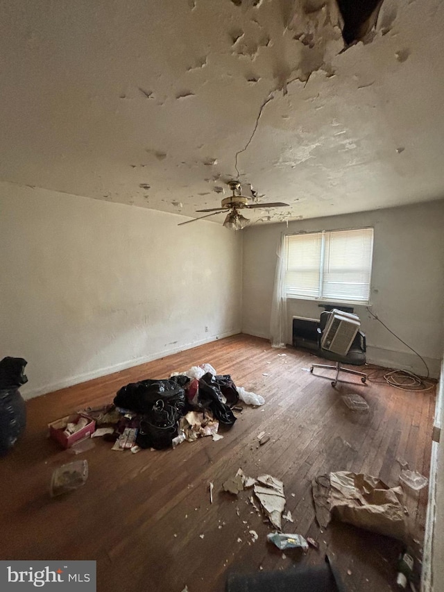 interior space featuring hardwood / wood-style flooring, baseboards, and a wall mounted AC