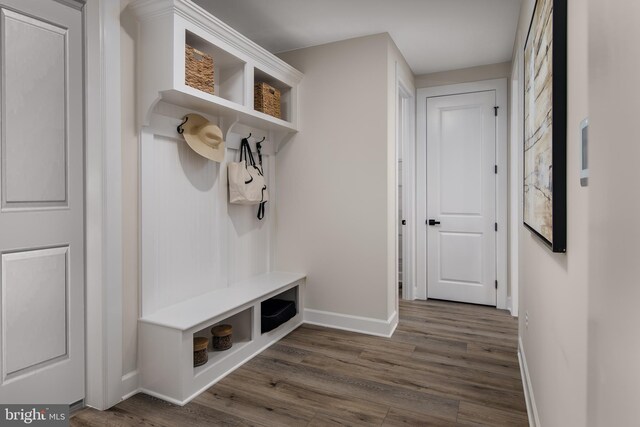 mudroom with dark wood-style flooring and baseboards