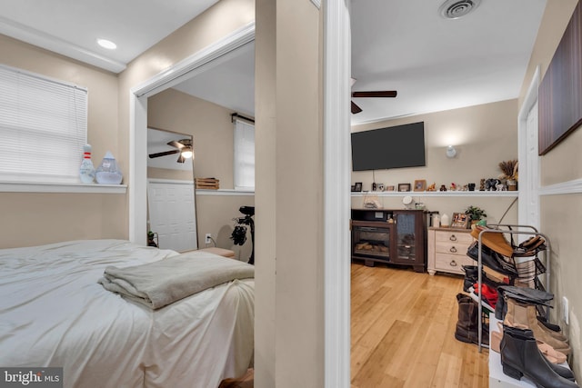 bedroom featuring visible vents, ceiling fan, and wood finished floors