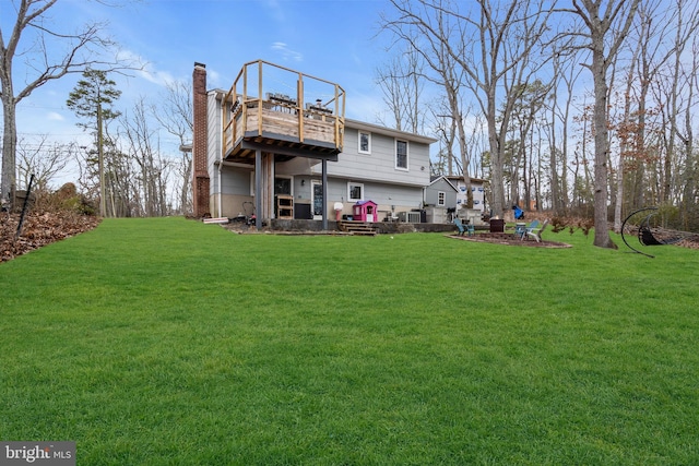 rear view of property with a deck and a lawn