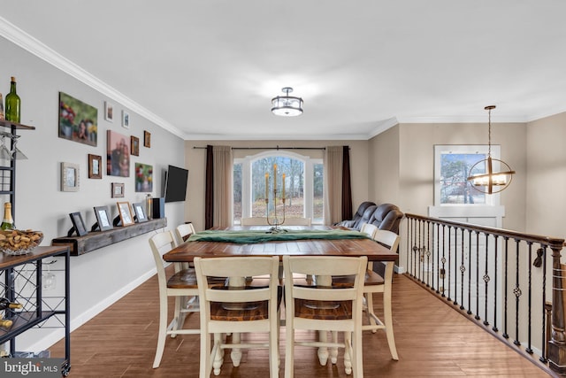 dining area with baseboards, plenty of natural light, wood finished floors, and an inviting chandelier