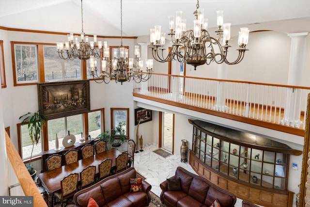 living area with high vaulted ceiling, marble finish floor, and a chandelier