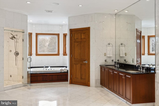 bathroom with a sink, visible vents, tile walls, a shower stall, and a bath