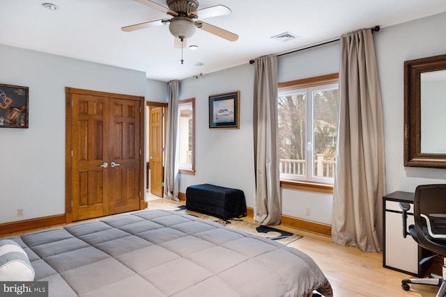 bedroom featuring light wood-style floors, baseboards, visible vents, and ceiling fan