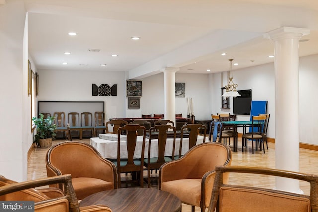 interior space featuring recessed lighting, baseboards, ornate columns, and wood finished floors