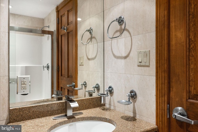 full bathroom featuring vanity, walk in shower, and tile walls