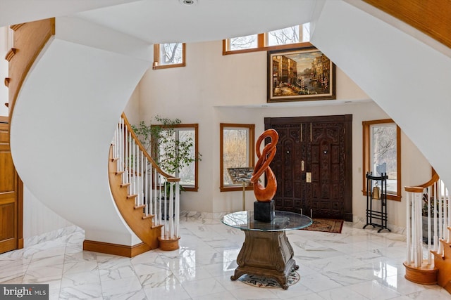 entrance foyer with marble finish floor and stairway