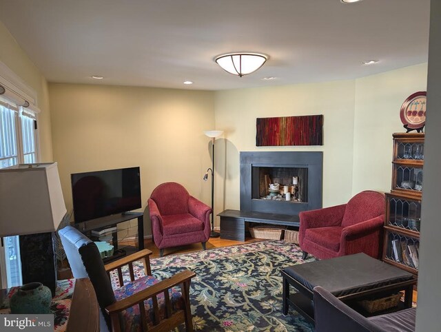 living room with a fireplace with raised hearth and recessed lighting