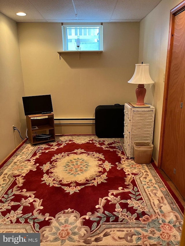 bedroom featuring carpet, a baseboard radiator, and a paneled ceiling