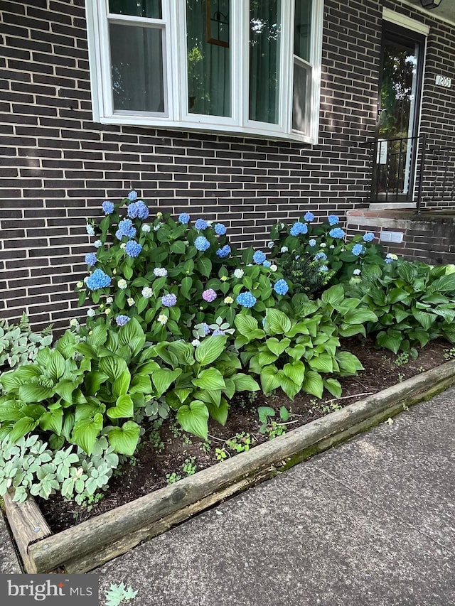 exterior details with a garden and brick siding