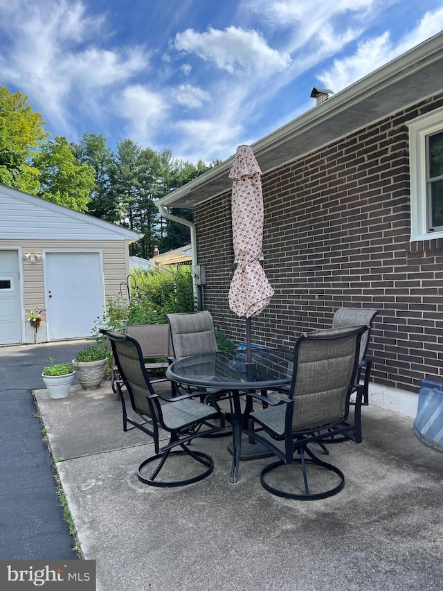 view of patio featuring outdoor dining space and an outdoor structure