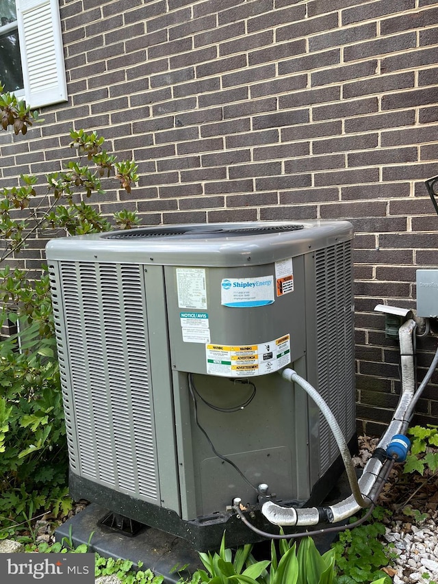 exterior details featuring brick siding and cooling unit